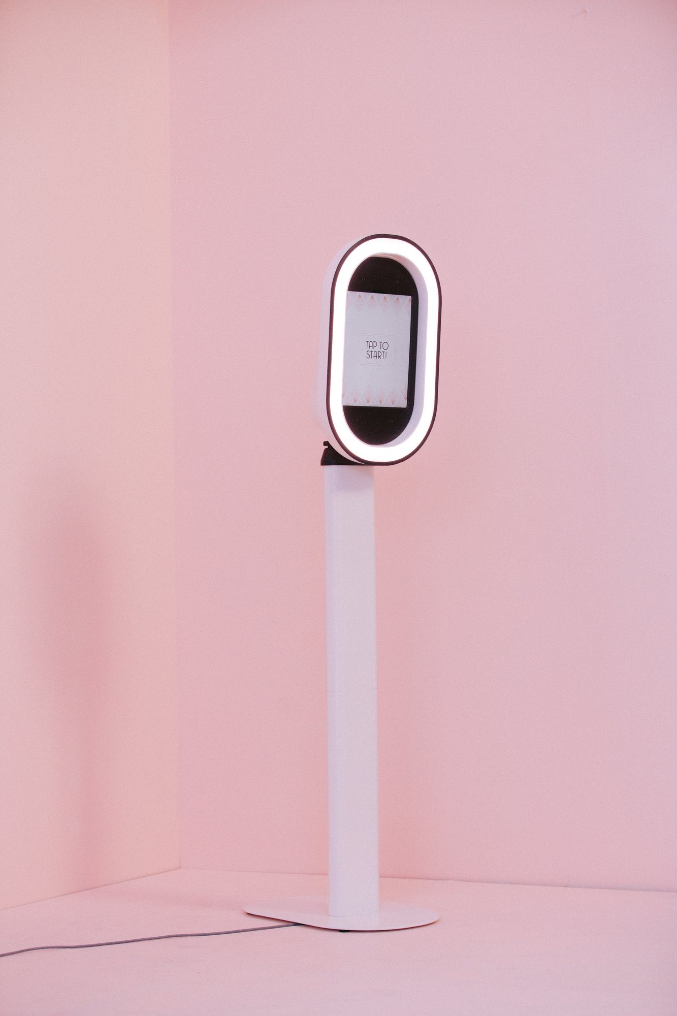 A June Light photo booth standing ready against a pink wall