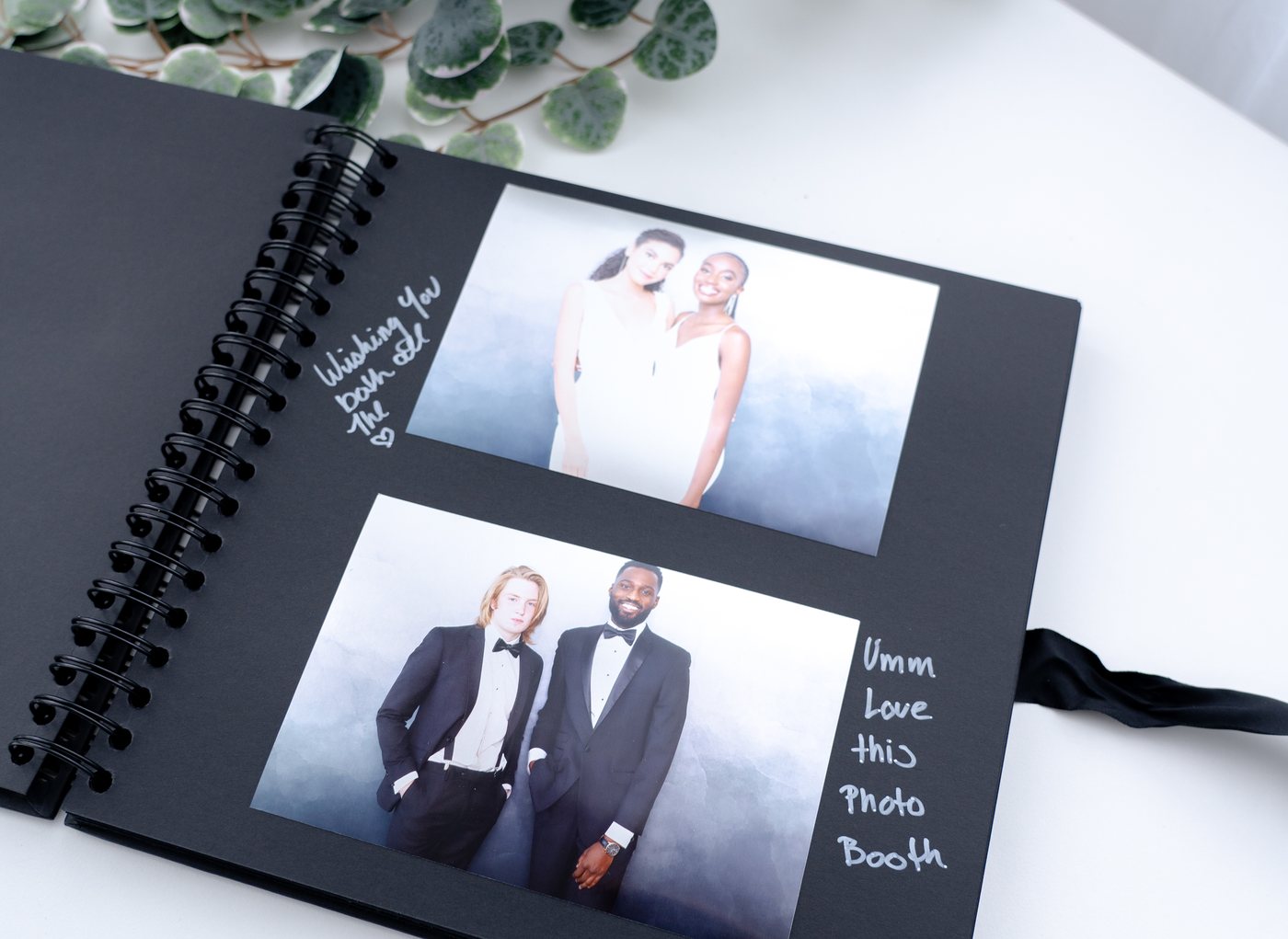 An open keepsake book showing printed photo strips from an event