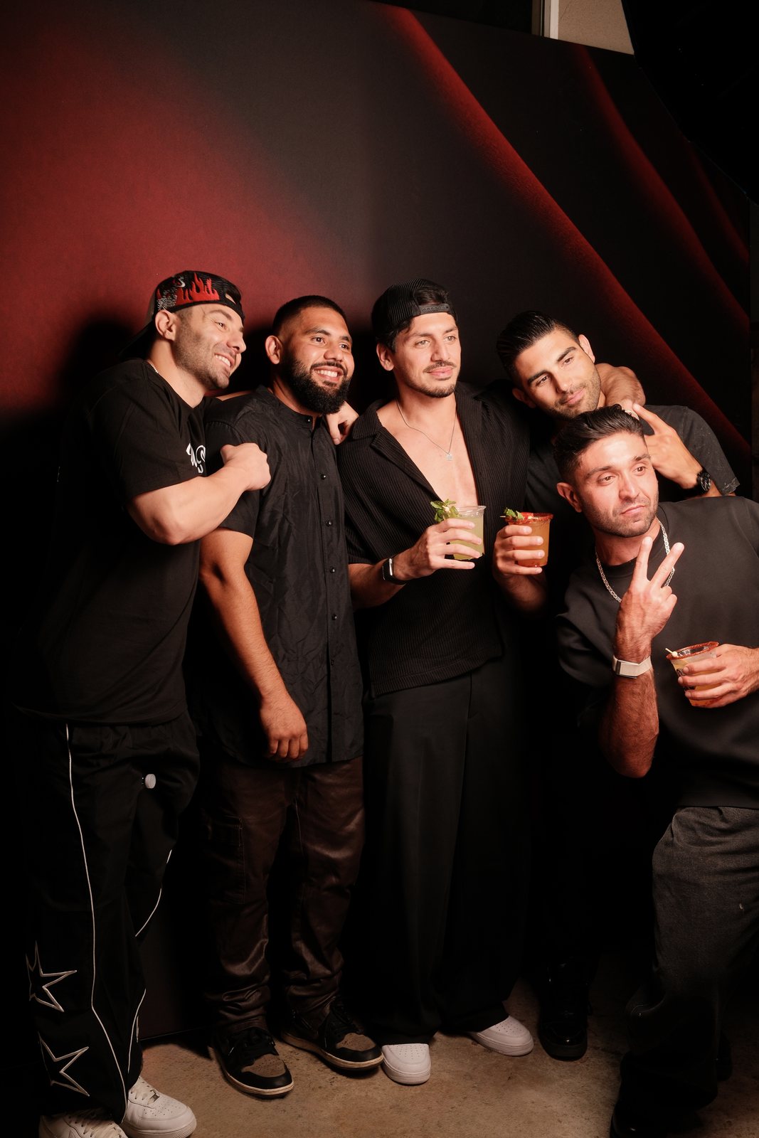A group of guests crowding in together under deep red light