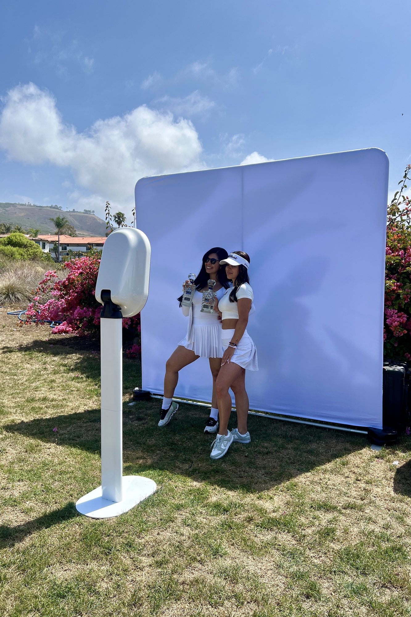 Guests at the photo booth on a lawn under an open sky